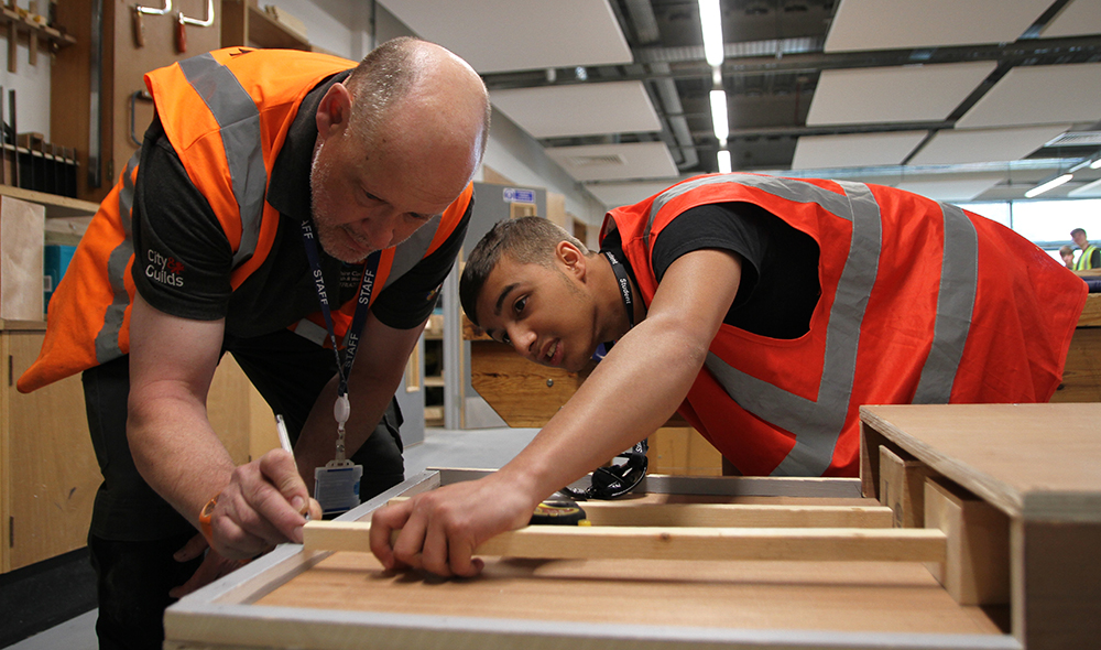 Carpentry learner with a tutor.