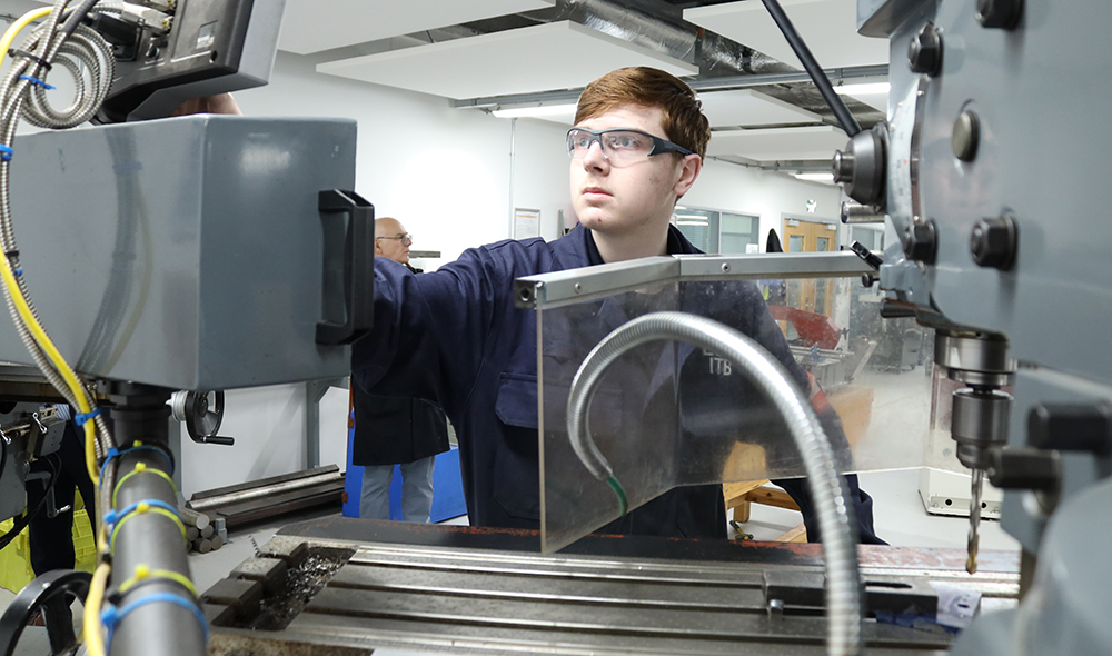 Engineering student operating a drill