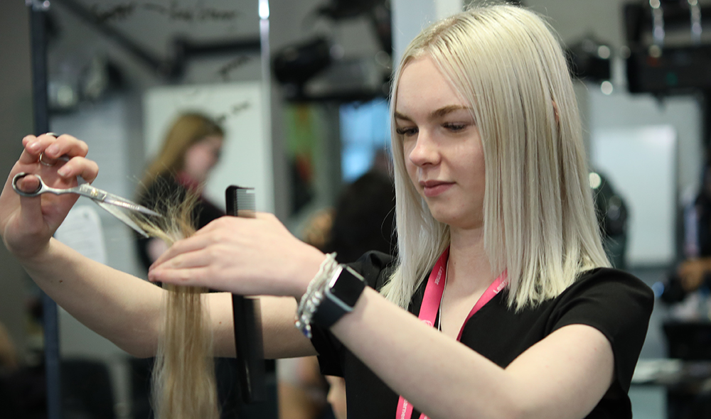 Hairdressing student cutting hair