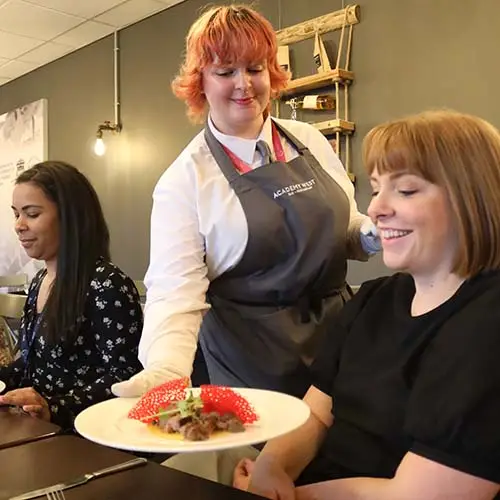 Hospitality student serving a customer