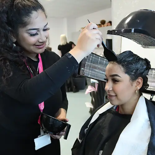 Hairdressing student dyeing hair