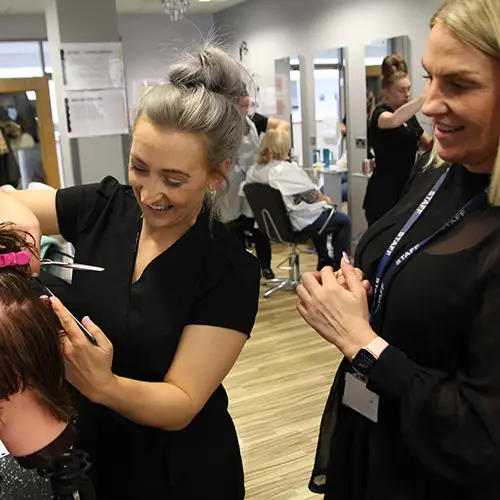 Hairdressing student cutting hair