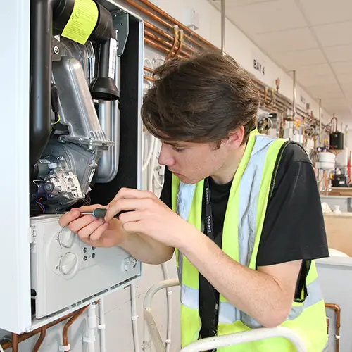 Plumbing student servicing boiler