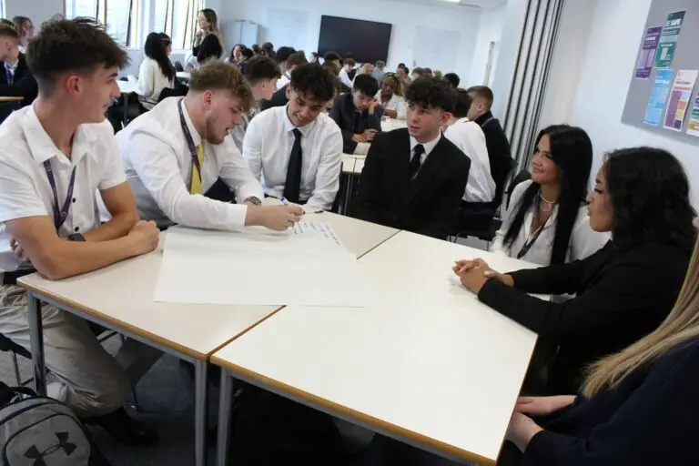 business students in a classroom all sat around a big table