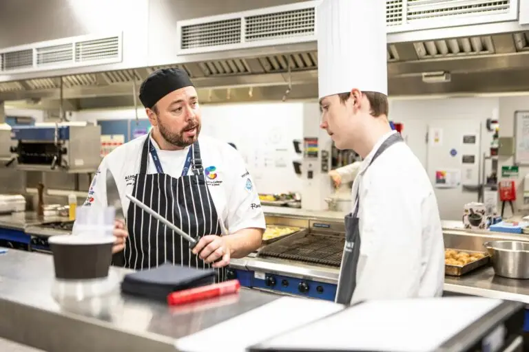 Hospitality and Catering tutor and student in commercial kitchen